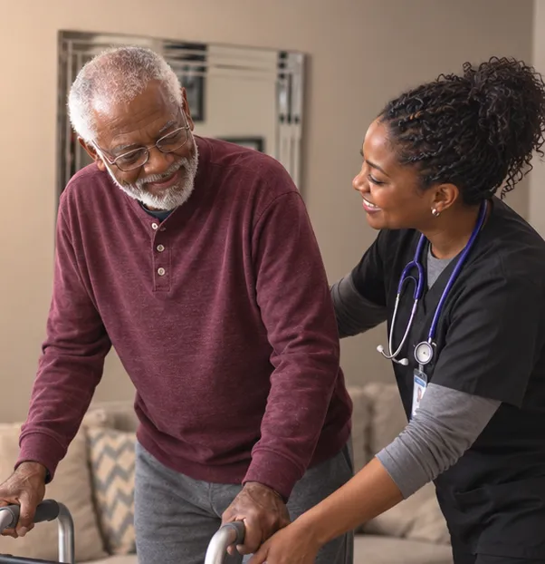 A physical therapist helping a patient walk with a walker